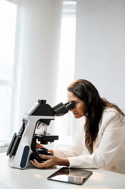 Dra. Melina Martins, ginecologista, analisando uma lâmina ao microscópio em seu consultório na Barra da Tijuca.